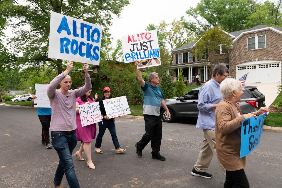 Demonstrators show their support for Justice Samuel Alito outside his home, background, on Thursday, May 5, 2022, in Alexandria, Va. A leaked draft opinion suggests the U.S. Supreme Court could be poised to overturn the landmark 1973 Roe v. Wade case that legalized abortion nationwide.