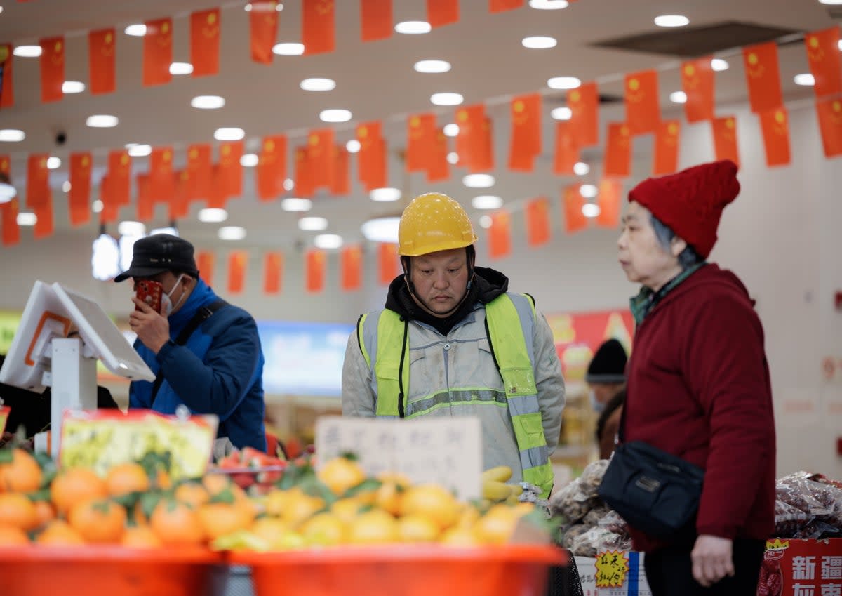 People stand in a grocery store in Shanghai, China (EPA)