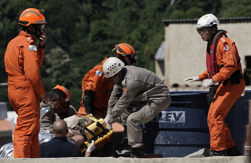 Firefighters remove on a stretcher a woman rescued from the rubble of two buildings that collapsed in the Muzema neighborhood, Rio de Janeiro, Brazil, Friday, April 12, 2019. The collapse came in a western part of the city that was particularly hard hit by heavy rains this week that caused massive flooding. (AP Photo/Leo Correa)