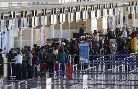 Passengers waits for their flights at the departure area inside the international airport of Santiago, Chile December 17, 2015. REUTERS/Carlos Vera