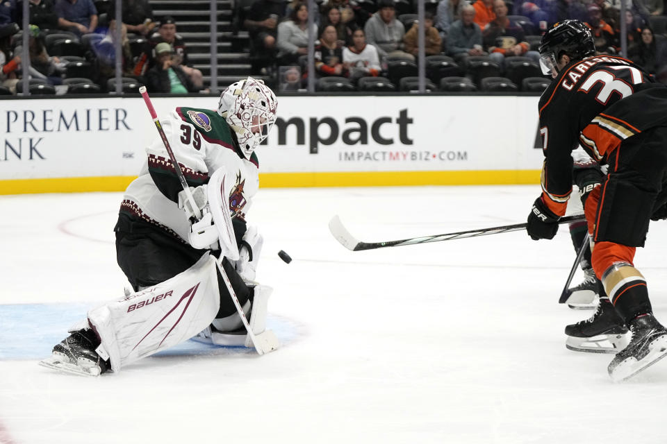 Anaheim Ducks center Leo Carlsson, right, tries to get a shot past Arizona Coyotes goaltender Connor Ingram during the third period of a preseason NHL hockey game Thursday, Oct. 5, 2023, in Anaheim, Calif. (AP Photo/Mark J. Terrill)