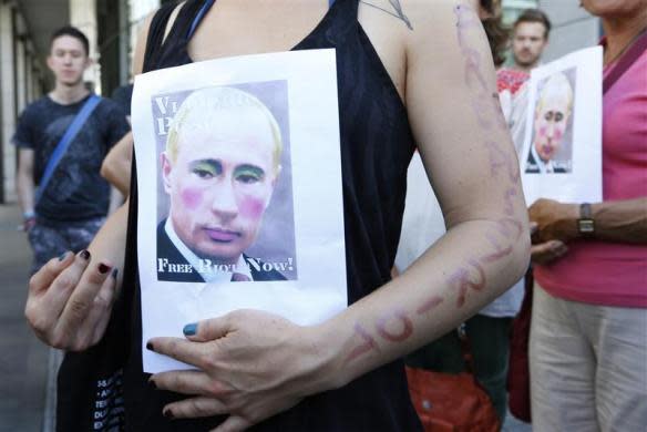 Activists hold banners depicting Russian President Vladimir Putin during a protest in support of members of the female punk band Pussy Riot in front of the Russian delegation to the European Union in Brussels August 17, 2012.