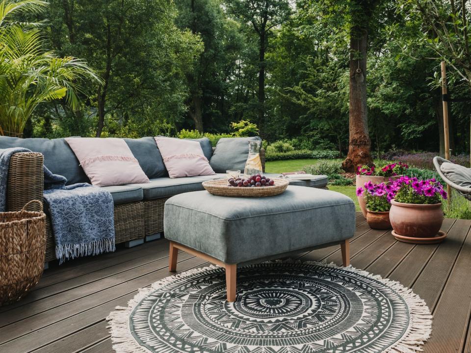 Garden patio decorated with Scandinavian wicker sofa and coffee table