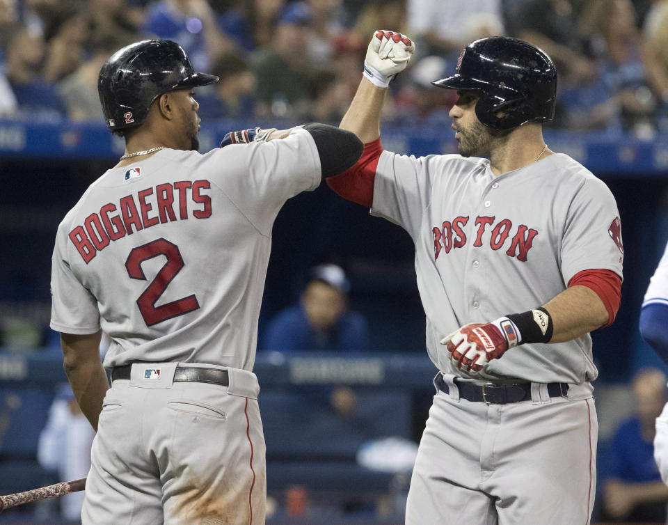 Boston Red Sox's J. D. Martinez is greeted by Xander Bogaerts at home plate after hitting a solo home run against the Toronto Blue Jays during the fifth inning of a baseball game Thursday, Aug. 9, 2018, in Toronto. (Fred Thornhill/The Canadian Press via AP)