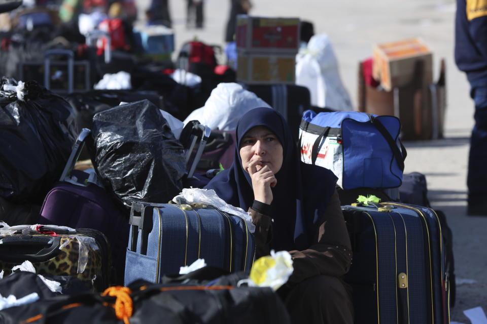 Palestinians stranded in Egypt wait to cross the Rafah crossing to the Gaza Strip at Rafah, Egypt, as a temporary ceasefire went into effect Friday, Nov. 24, 2023. (AP Photo/Mohammed Asad)