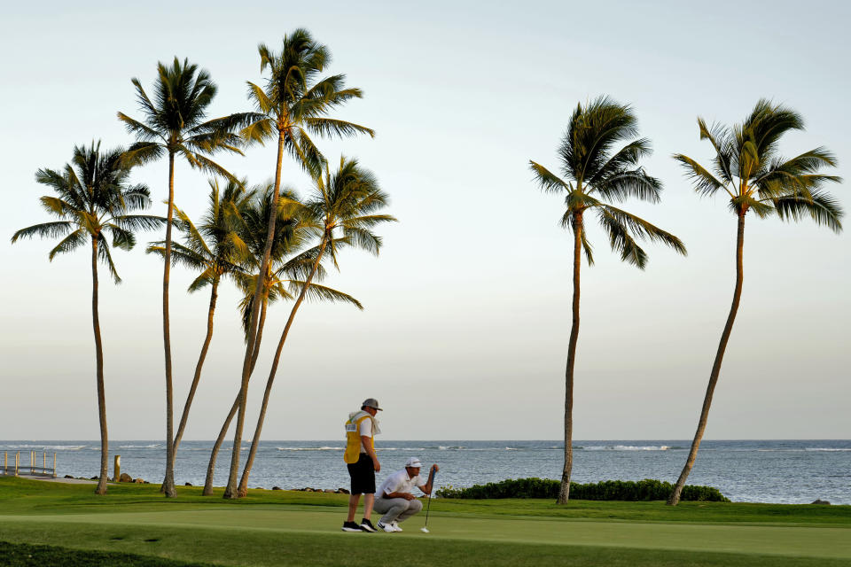 Taylor Montgomery lines up his shot with his caddie on the 17th green during the first round of the Sony Open golf tournament, Thursday, Jan. 12, 2023, at Waialae Country Club in Honolulu. (AP Photo/Matt York)