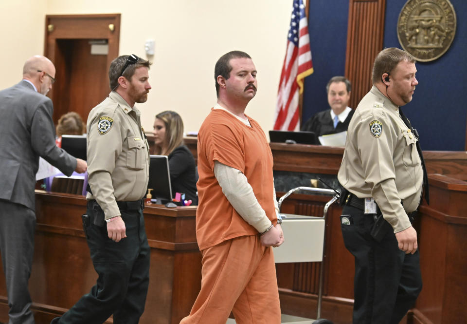 Michael Helterbrand is escorted out after Judge Jack Niedrach denied a bond at Floyd County Superior Court in Rome, Ga., on Friday, Feb. 14, 2020. Bond was denied Friday for two Georgia men, 19-year-old Jacob Kaderli of Dacula and 25-year-old Helterbrand of Dalton, authorities say are linked to a violent white supremacist group known as The Base. The two men are charged, along with 22-year-old Luke Lane of Silver Creek, of conspiring to kill members of a militant anti-fascist group and participating in a criminal gang. (Hyosub Shin/Atlanta Journal-Constitution via AP)