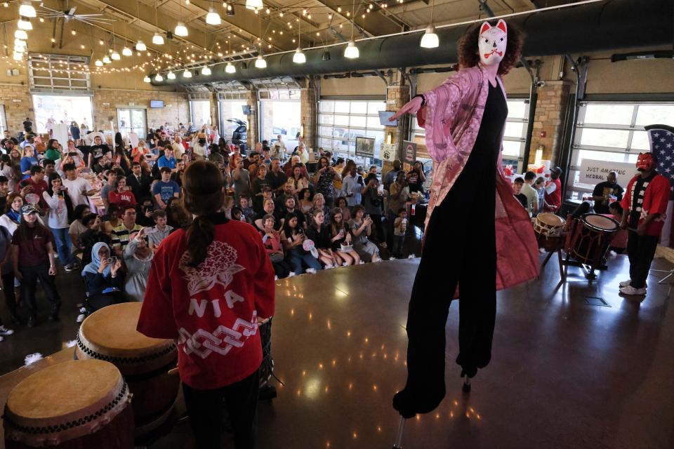 Dancers and drummers with Nozomi Daiko during the 37th Annual Sakura Festival at Tuscaloosa River Market, March 25, 2023. Sara Naughton performs on stilts and in mask and costume. The 2024 Sakura Festival will be Saturday at the Warner Transportation Museum.