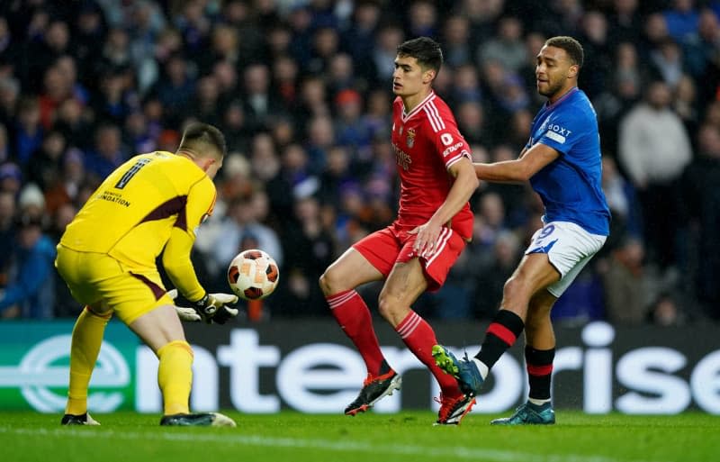 Benfica's Antonio Silva holds off Rangers' Cyriel Dessers as Benfica goalkeeper Anatoliy Trubin collects the ball during the UEFA Europa League Round of 16, second leg soccer match between Rangers and Benfica at the Ibrox Stadium. Andrew Milligan/PA Wire/dpa