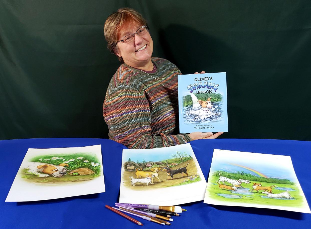 Freeport native Teri Runte Peacock holds a copy of the children's book she wrote and illustrated in honor of her dog Oliver. The book is titled "Oliver's Swimming Lesson."
