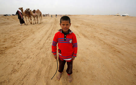 Fahad, an 8-year-old jockey, looks on during the opening of the International Camel Racing festival at the Sarabium desert in Ismailia, Egypt, March 21, 2017. Picture taken March 21, 2017. REUTERS/Amr Abdallah Dalsh