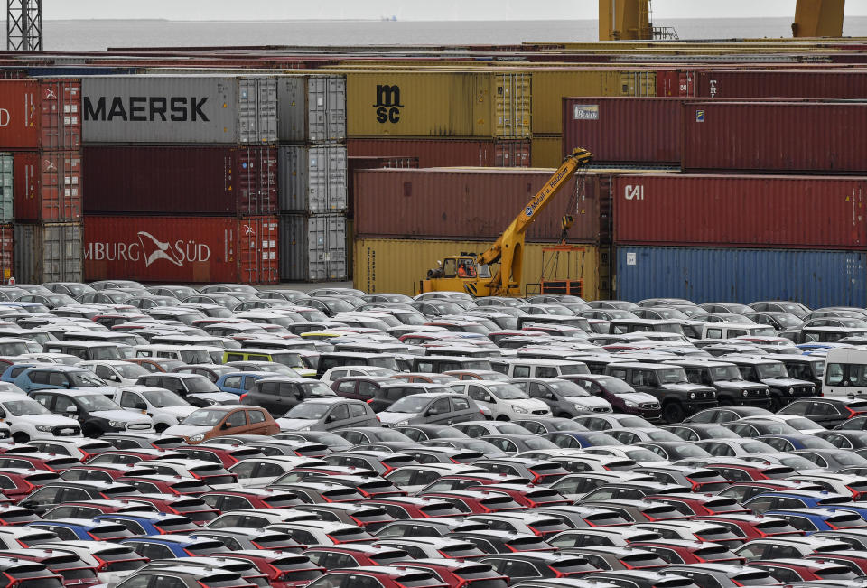 FILE - In this Thursday, May 16, 2019 photo cars for export and import are stored in front of containers at the harbor in Bremerhaven, Germany. The German economy shrank by 0.1 percent in the second quarter as global trade conflicts and troubles in the auto industry weighed on Europe's largest economy. (AP Photo/Martin Meissner, file)