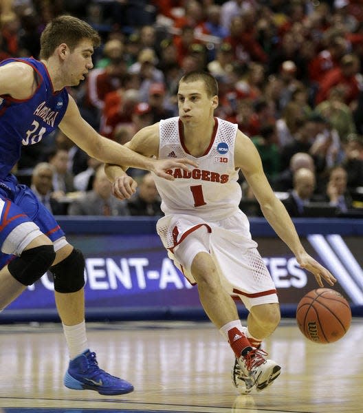 Wisconsin guard Ben Brust (1) drives against American center Tony Wroblicky (34) during the second half of a second-round game in the NCAA college basketball tournament Thursday, March 20, 2014, in Milwaukee. (AP Photo/Jeffrey Phelps)