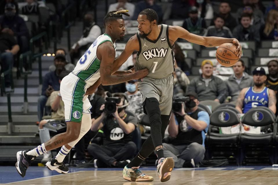 Dallas Mavericks forward Reggie Bullock, left, defends as Brooklyn Nets forward Kevin Durant (7) works for a shot in the first half of an NBA basketball game in Dallas, Tuesday, Dec. 7, 2021. (AP Photo/Tony Gutierrez)