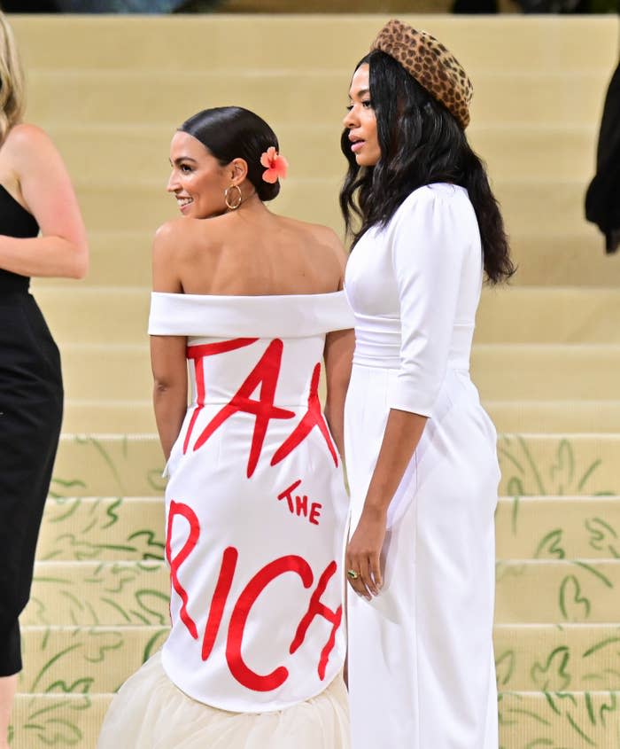 The New York congresswoman's white gown was designed by Aurora James, who joined AOC at the Met Gala. AOC also wore the statement on a red purse.