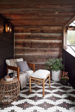 Photography by Brian Woodcock; Styling by Natalie Warady Chambers, who was known around Highlands for restoring historic log cabins, hand-hewed the beams on the second-floor porch. The patterned tile flooring is by Clé.