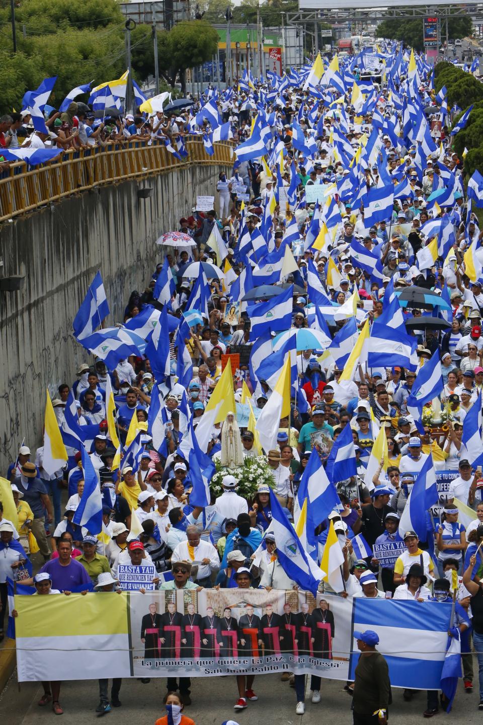 Anti-government demonstrators hold a banner showing a group photo of clerics, during a march supporting the Catholic church, in Managua, Nicaragua, Saturday, July 28, 2018. At least 448 people have been killed, most of them protesters, since the protests began in April. Demonstrators were initially upset over proposed social security cuts but are now demanding President Daniel Ortega leave office after a deadly crackdown by security forces and armed pro-government civilians. (AP Photo/Alfredo Zuniga)