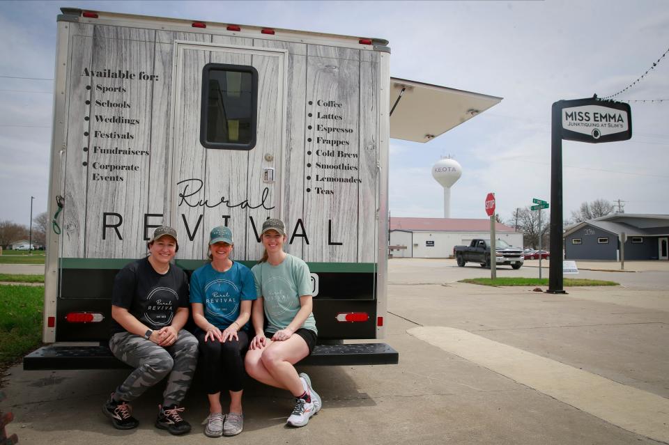 Naomi Gretter, left, Kari Berg, and Sky Hahn, right, owners of the Rural Revival mobile coffee truck, pose for a photo outside of their truck during a stop in Keota, Iowa, on Saturday, April 23, 2022.