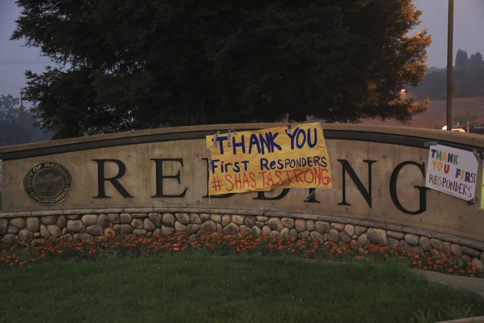 Signs of encouragement for first responders is hung on a city sign in Redding, Calif., July 31.