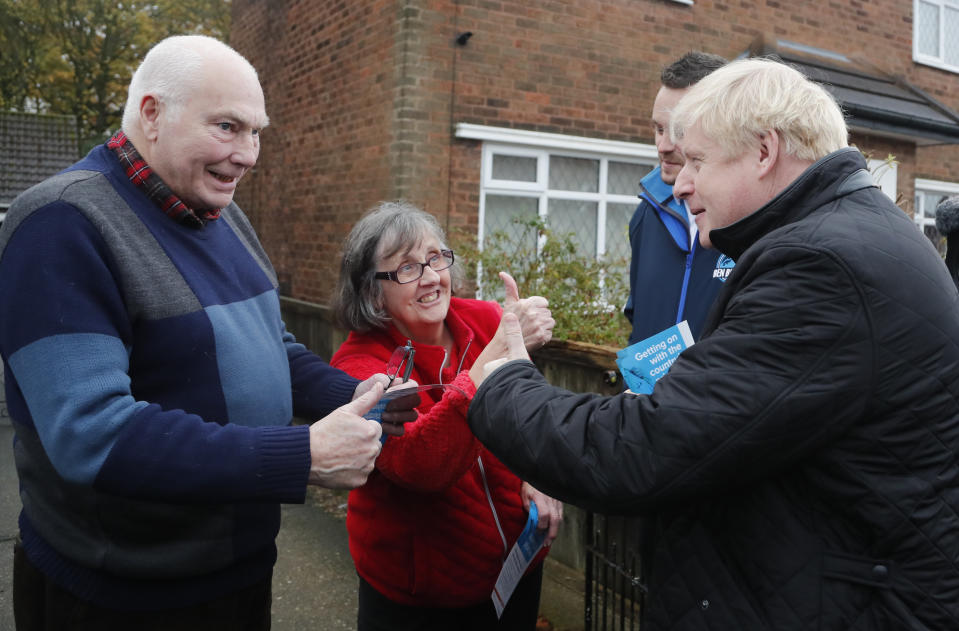 Britain's Prime Minister Boris Johnson, right, speaks to voters, one of which give him a thumbs up, in the Mansfield constituency as he canvases during a General Election campaign trail stop in Mansfield, England, Saturday, Nov. 16, 2019.Britain goes to the polls on Dec.12. (AP Photo/Frank Augstein, Pool)