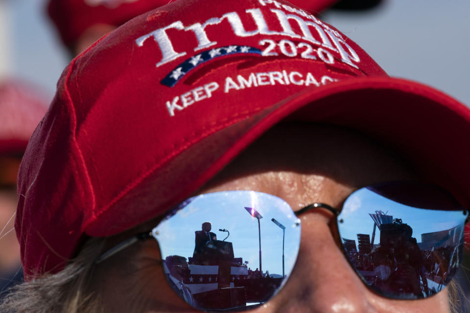 Reflected in a supporter's sunglasses, President Donald Trump speaks at a campaign rally at Tucson International Airport, Monday, Oct. 19, 2020, in Tucson, Ariz. (AP Photo/Alex Brandon)