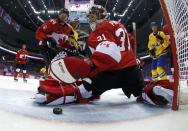 Canada's goalie Carey Price reaches back to glove a loose puck as Canada's Marc-Edouard Vlasic looks on during their men's ice hockey gold medal game against Sweden at the Sochi 2014 Winter Olympic Games February 23, 2014. REUTERS/Julio Cortez/Pool (RUSSIA - Tags: SPORT ICE HOCKEY OLYMPICS)