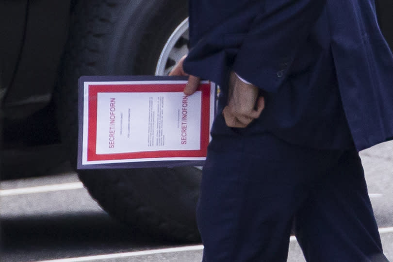 Outgoing acting Defense Secretary Patrick Shanahan carries a document labeled secret as he arrives for a meeting with President Donald Trump about Iran at the White House, Thursday, June 20, 2019, in Washington. (AP Photo/Alex Brandon)