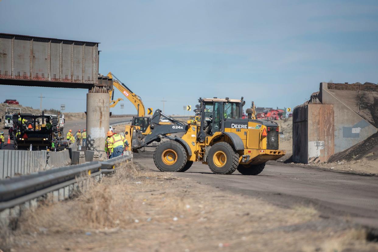 Construction crews work to clean up and repair Interstate 25 at the site of Sunday's fatal train derailment on Wednesday, October 18, 2023..