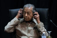 Malaysia's interim leader Mahathir Mohamad adjusts his headphone as he attends the committee on the exercise of the inalienable rights of the Palestinian people, in Kuala Lumpur, Malaysia, Friday, Feb. 28, 2020. The speaker of Malaysia's House rejected Mahathir Mohamad's call for a vote next week to chose a new premier, deepening the country's political turmoil after the ruling alliance collapsed this week. (AP Photo/Vincent Thian)