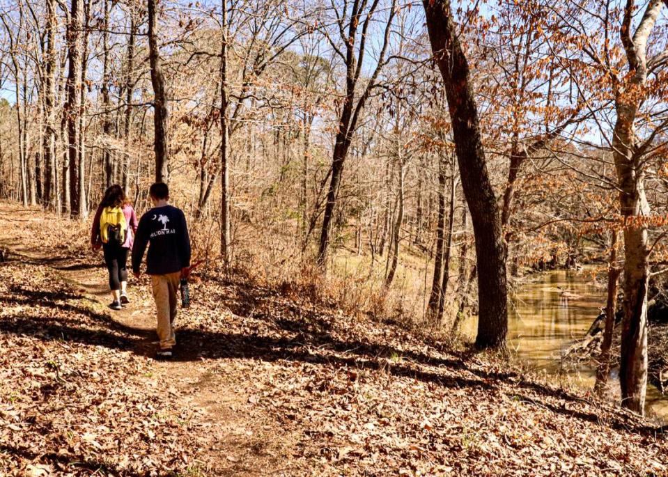 Hikers enjoy the sunny winter afternoon along the Turkey Creek Trail near Augusta. The trail is moderately challenging as it ascends and descends the bluffs along the creek, which flows over rocky falls below. 