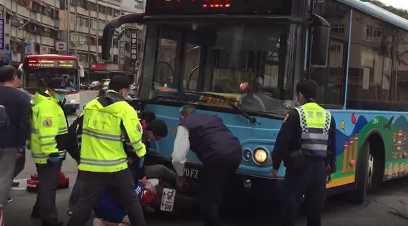 騎士遭公車擦撞卡車底，十多人合力抬公車救人。