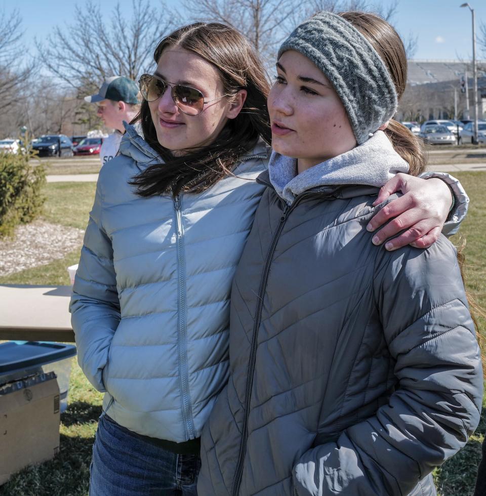 Ellie Barron, a sophomore at Michigan State, left, and friend Cheyanne Schlinke, a freshman, choke up a bit as they talk about their experience last month during the mass shooting on campus. The event, dubbed Walk Together, on Sunday, March 19, 2023, allowed students to write down their thoughts on cards to be archived and displayed at the Michigan State Museum.