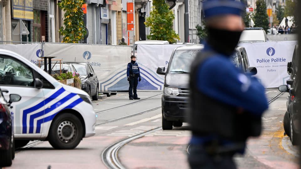Police officers stand guard in front of the house in the Schaerbeek area of Brussels on October 17, 2023, where the suspected perpetrator of the attack in Brussels was shot dead during a police intervention. - John Thys/AFP/Getty Images