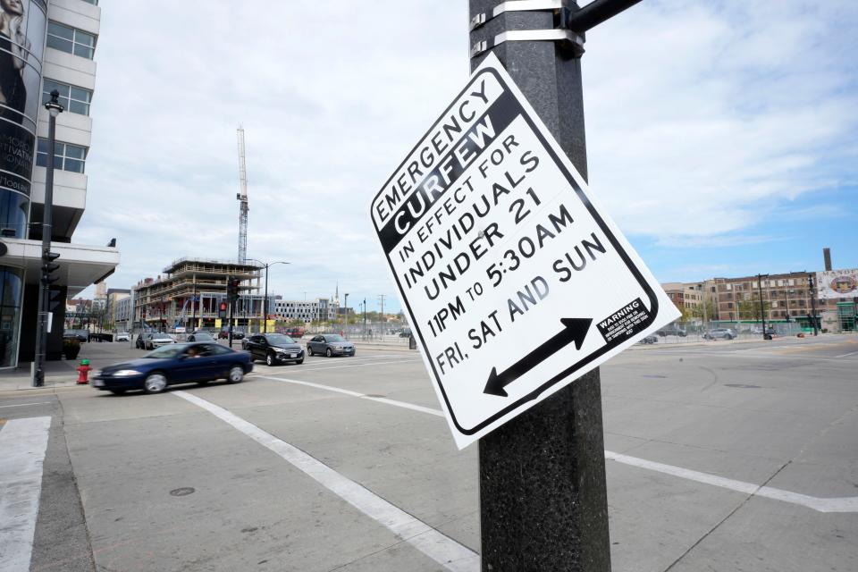 An emergency curfew sign hangs on the corner of East Juneau and North King Drive in Milwaukee on Sunday, May 15, 2022 . In addition to the curfew, following a series of shootings Friday night after the Bucks lost to Boston to force a Game 7 on Sunday afternoon, the Bucks elected to cancel the watch party on the plaza in front of Fiserv Forum.