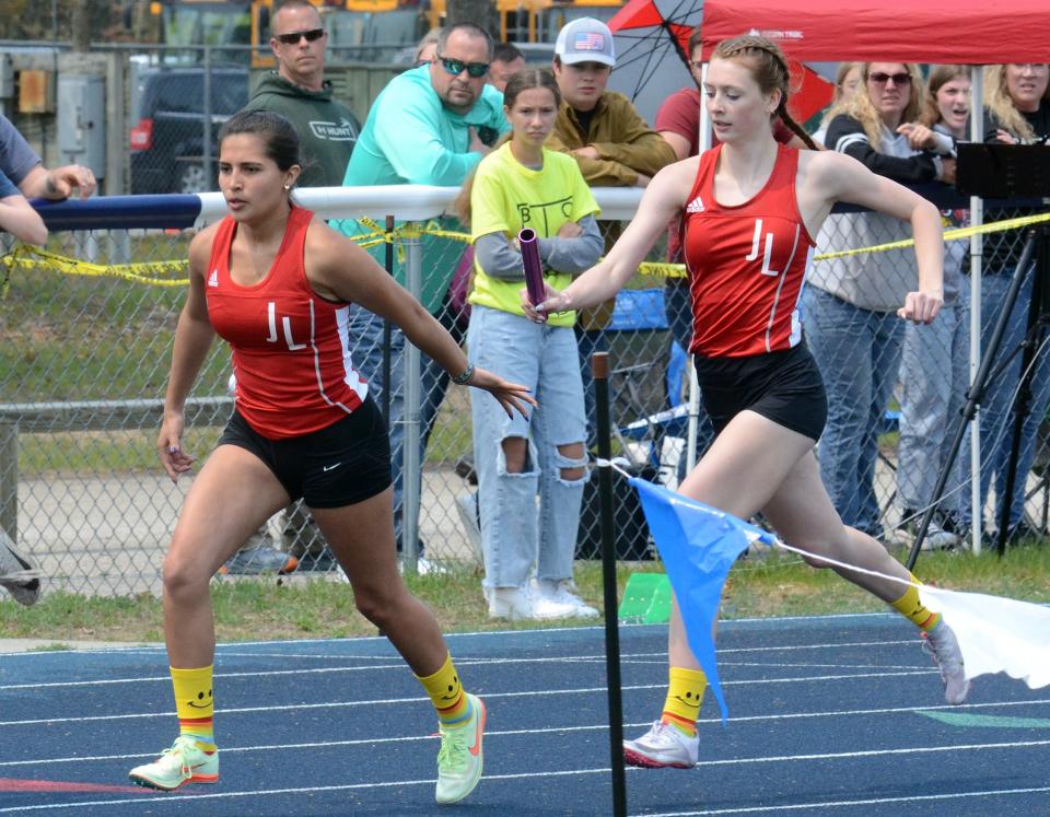 Yolanda Gascho (left) receives a handoff from Carlee Campbell (right) during the MHSAA Region 31-4 track meet on Friday, May 19 in Indian River, Mich.