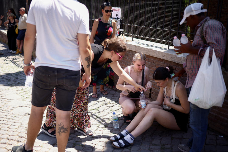 A tourist from the UK receives help near the Colosseum after fainting during a heatwave across Italy, in Rome, Italy July 11, 2023. REUTERS/Guglielmo Mangiapne