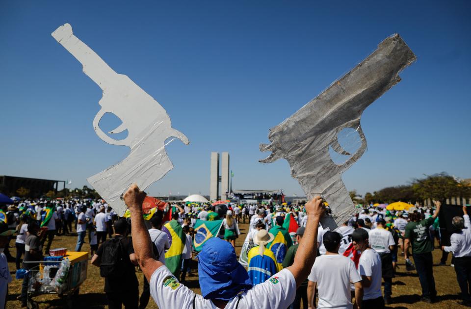Apoiador de Jair Bolsonaro segura cartazes em formato de arma; discurso de violência antes das eleições preocupa especialistas (Foto: SERGIO LIMA/AFP via Getty Images)