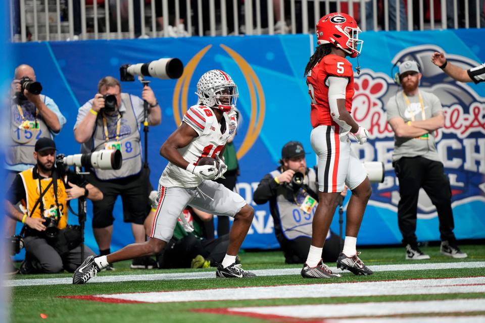 Dec 31, 2022; Atlanta, Georgia, USA; Ohio State Buckeyes wide receiver Marvin Harrison Jr. (18) makes a touchdown catch against Georgia Bulldogs defensive back Kelee Ringo (5) during the second quarter of the Peach Bowl in the College Football Playoff semifinal at Mercedes-Benz Stadium. 