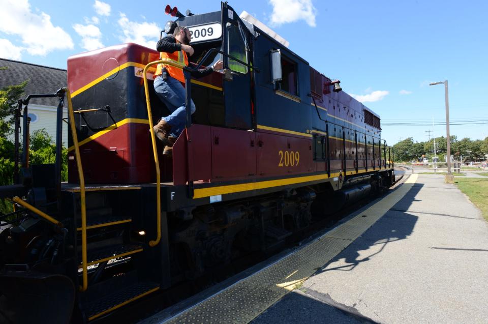 Mass Coastal Railroad conductor Mike Valle climbs back into the engine on Sept. 21 as the train leaves the Buzzards Bay station heading north to its destination in Middleboro with car loads of construction debris.