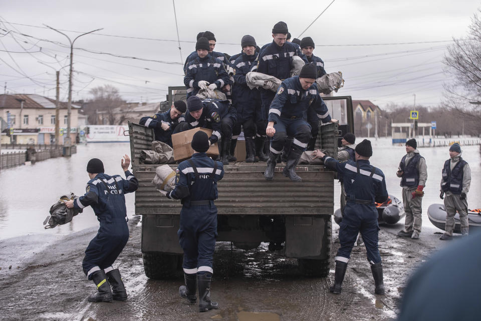 Emergency workers get off a truck during evacuations in a flooded street after parts of a dam burst, in Orsk, Russia on Monday, April 8, 2024. Floods caused by rising water levels in the Ural River broke a dam in a city near Russia's border with Kazakhstan, forcing some 2,000 people to evacuate, local authorities said. The dam broke in the city of Orsk in the Orenburg region, less than 12.4 miles north of the border on Friday night, according to Orsk mayor Vasily Kozupitsa. (AP Photo)