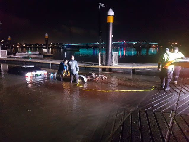 Police attempt to pull the car from the Brisbane River. Source: Queensland Police Service