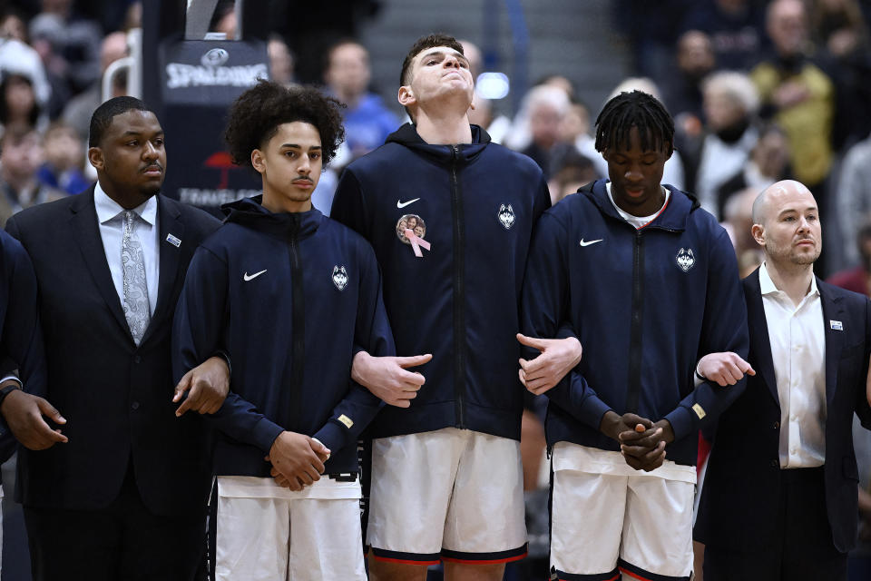 UConn center Donovan Clingan, center, raises his head during a pregame ceremony for Coaches vs Cancer before an NCAA college basketball game against Xavier, Sunday, Jan. 28, 2024, in Hartford, Conn. Clingan's mother, Stacey Clingan, died of breast cancer in 2018. (AP Photo/Jessica Hill)