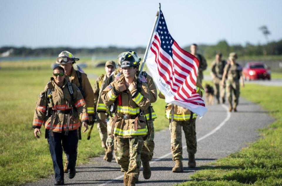Firefighters with the 1st Special Operations Civil Engineer Squadron carry the American flag during a 5-mile memorial ruck march at Hurlburt Field on Sept. 10, 2021. Airmen, family members and community partners from across Hurlburt Field and the local area participated in the event to pay tribute to the almost 3,000 victims of the 9/11 terrorist attacks.