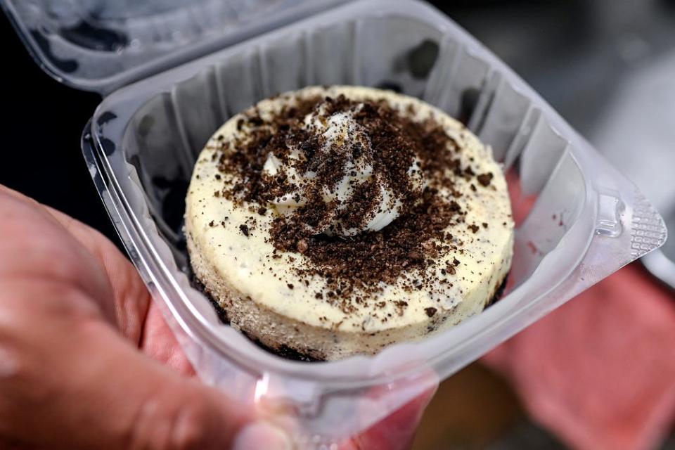 Marcus Leslie, owner of Leslie's Cheesecakes, shows off a finished cookies and cream cheesecake on Wednesday, March 10, 2021, in the accelerator kitchen at the Allen Neighborhood Center in Lansing.