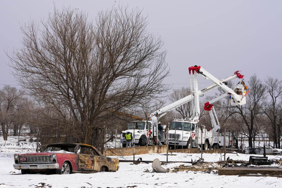 FILE - Utility workers from Xcel Energy labor on power lines near a home destroyed by the Smokehouse Creek Fire, Thursday, Feb. 29, 2024, in Stinnett, Texas. The utility provider Xcel Energy said Thursday, March 7, 2024 that its facilities appeared have played a role in igniting a massive wildfire in the Texas Panhandle that grew to the largest blaze in state history. (AP Photo/Julio Cortez, file)