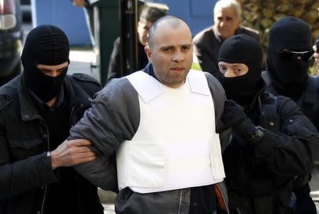 Nikolaos Maziotis (C), is escorted by policemen to a prosecutor's office in Athens April 12, 2010. REUTERS/Stringer