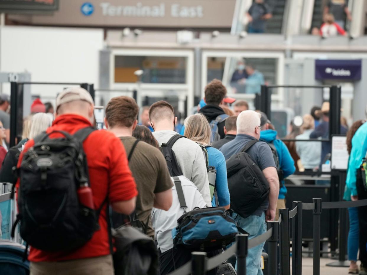 Travelers queue up at the north security checkpoint in the main terminal of Denver International Airport, Thursday, May 26, 2022, in Denver.