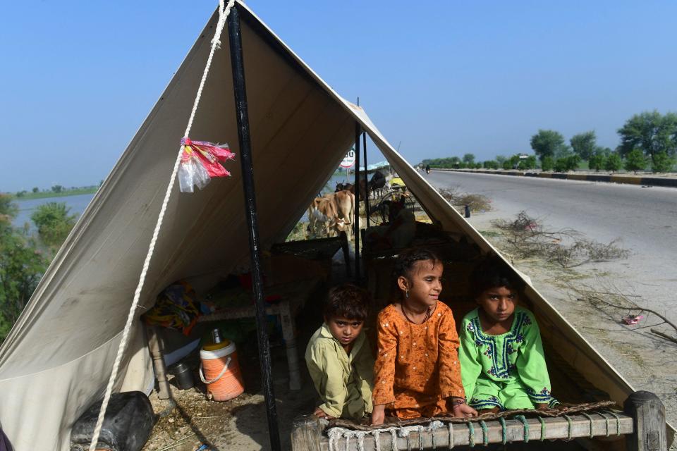 Children whose families were displaced by flooding sit in a tent along a roadside in Shikarpur, in Pakistan's southern Sindh province, August 30, 2022. / Credit: ASIF HASSAN/AFP/Getty