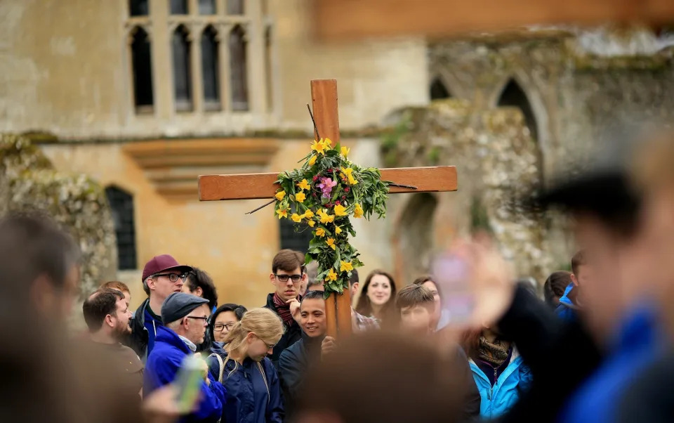 Pilgrims carry their cross through Walsingham on the final leg of their easter pilgrimage - Getty 