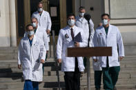 El doctor del presidente Donald Trump, Sean Conley, (centro) y otros médicos caminan para hablar con los reporteros en el Centro Médico Militar Nacional Walter Reed, el lunes 5 de octubre de 2020, en Bethesda, Maryland. (AP Foto/Evan Vucci)